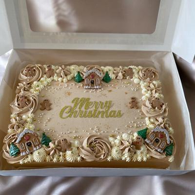 A beautifully decorated Christmas cake with festive designs, featuring the words