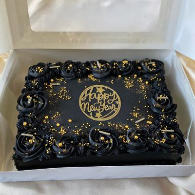 Black rectangular cake decorated with black roses and golden accents, featuring a